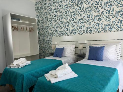 two beds in a room with blue and white wallpaper at Mare Azzurro in Torre del Greco