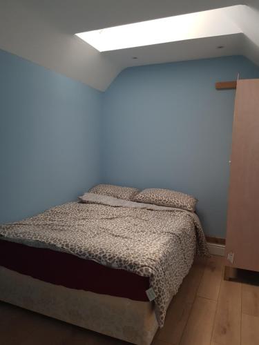 een slaapkamer met een bed in een blauwe muur bij Cosy Studio Luton in Luton