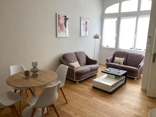 un salon avec une table et des chaises dans l'établissement La Petite Maison, à Châteauroux