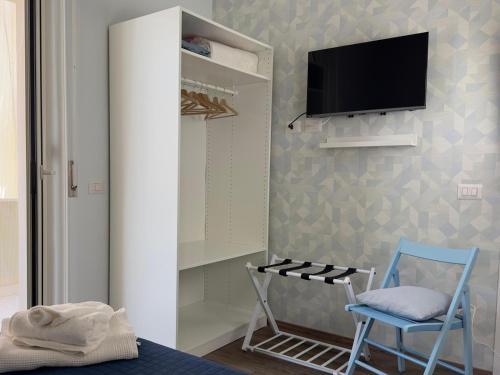 um quarto com uma cadeira e uma televisão na parede em Mare Azzurro em Torre del Greco