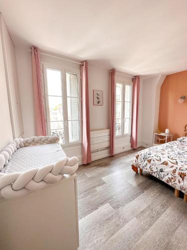 a bedroom with two beds and two windows at Logement entier 75 m2 in Boulogne-Billancourt