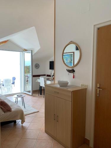 a kitchen with a sink and a mirror on the wall at Apartmani ANCORA, Crkvice in Kuna Pelješka