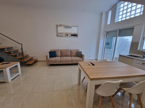 a living room with a table and a couch at Villa Alameda by Atlantichotels in Portimão