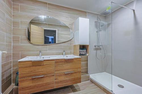 une salle de bain avec un lavabo, une douche et un miroir dans l'établissement Charme et confort - proche Tour Eiffel Paris 16, à Paris