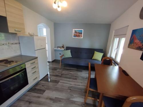 een keuken en een woonkamer met een bank en een tafel bij Apartman Marija in Zlarin