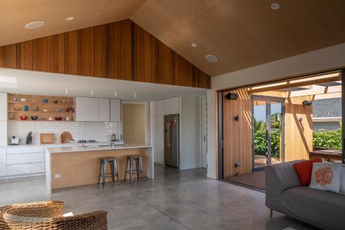 an open kitchen and living room in a house at Twin Peaks Beach House - New Plymouth Holiday Home in New Plymouth