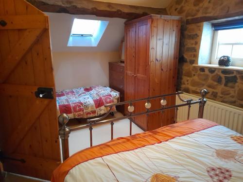 - une chambre avec un lit et des placards en bois dans l'établissement Moira Cottages at Berwickhall Sleeps 8, à Moira