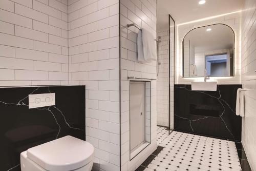 a bathroom with a toilet and a sink and a mirror at The Savoy Hotel on Little Collins Melbourne in Melbourne
