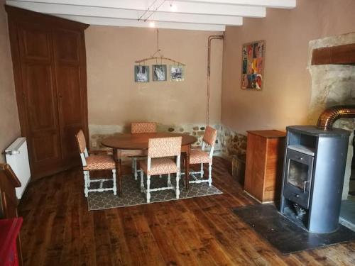 - une salle à manger avec une table et un poêle à bois dans l'établissement Le gîte du Tamlin, à Glandieu