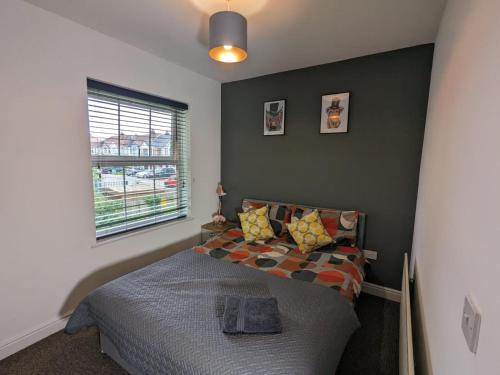 a bedroom with a bed and a window at Stylish Modern Apartment, FREE SECURE Parking in Allesley