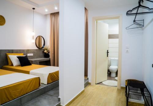 Habitación de hotel con 2 camas y aseo en Orama, en Faliraki
