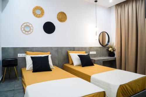two beds in a room with yellow and white at Orama in Faliraki