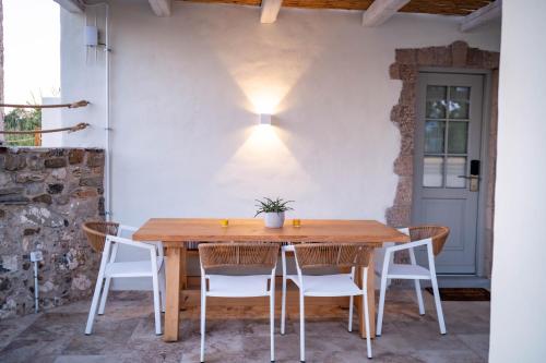 een houten tafel en stoelen op een patio bij The Windmill Villa in Lampi