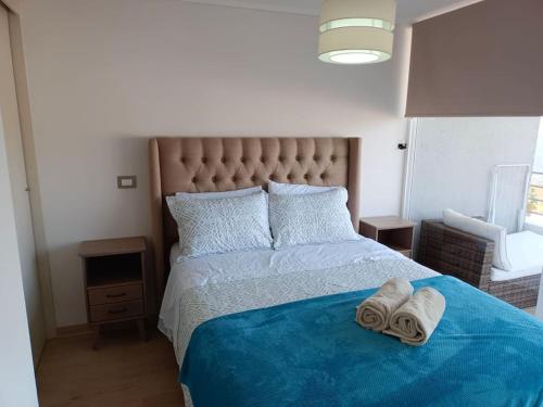 ビーニャデルマールにあるDepartamento 2D y 2B Viña del marのベッドルーム1室(大型ベッド1台、タオル付)