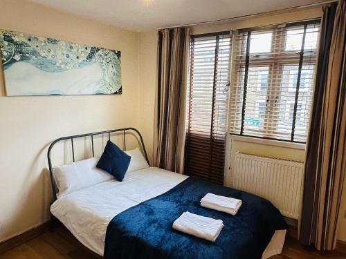 een slaapkamer met een bed met twee handdoeken erop bij London Mackenzie Apartment in Londen