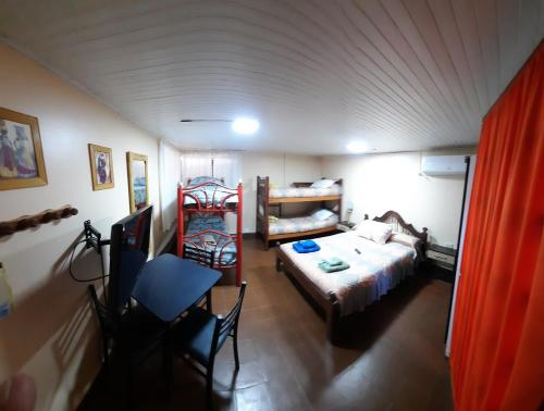 een slaapkamer met een bed en een tafel en stoelen bij La Rojarilla in San Miguel de Tucumán