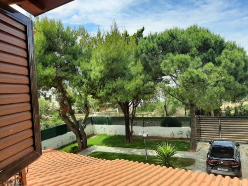 a house with a car parked in a yard with trees at Yannis Villa in Katarrákhion