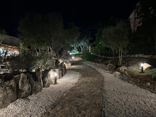 a garden at night with rocks and lights at Villa Aromata in Trudda