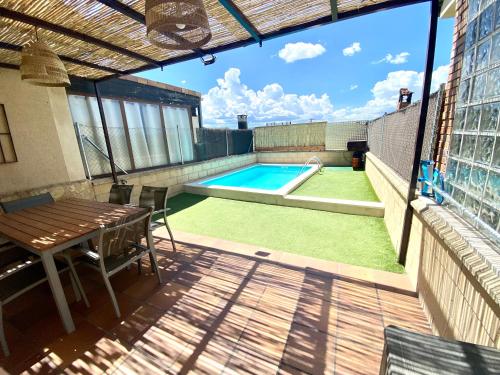 un patio con una mesa y una piscina en La espiga de la Mata, en Segovia