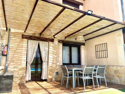 a patio with a table and chairs under awning at La espiga de la Mata in Segovia