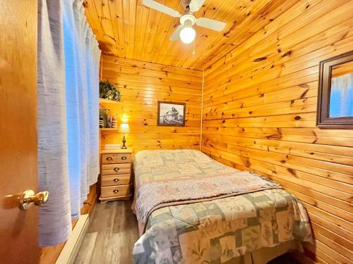 a bedroom with a bed in a wooden cabin at Stargazers Cove Cottages Blue Heron in Middleton