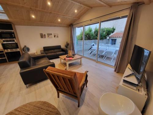 un salon avec un canapé et une télévision dans l'établissement Maison proche plages, port et tous commerces, à Les Sables-dʼOlonne