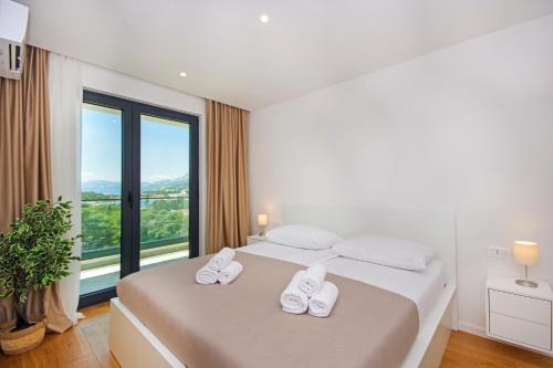 a bedroom with two beds and a large window at ATLANTIS LUX with pool in Makarska