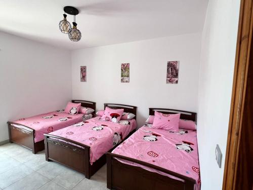 two beds in a room with pink sheets at شاليه بالميرا العين السخنة للعائلات فقط in Ain Sokhna