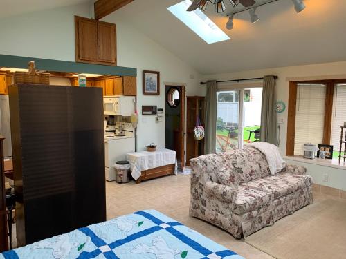 a living room with a couch and a kitchen at Lake Tapps Bungalow in Dieringer