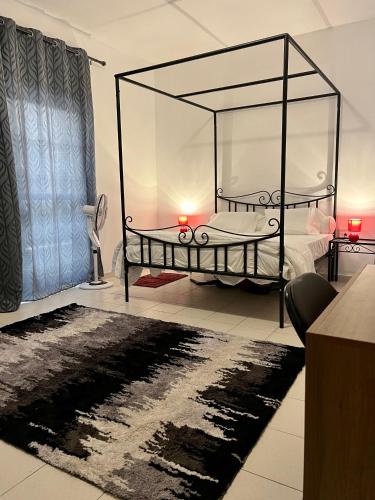 sypialnia z łóżkiem ze szklanym baldachimem w obiekcie The coolest room w mieście Rufisque