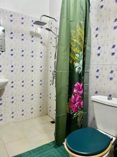 a bathroom with a shower with a blue toilet at The coolest room in Rufisque
