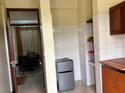 uma pequena cozinha com um frigorífico e uma mesa em Beckys Apartment in down Town Arusha 