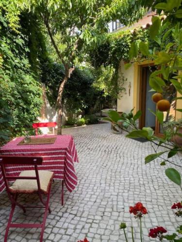 a table with a red and white table cloth on a patio at Villa Ávilla. Luxo e Charme. in Cascais