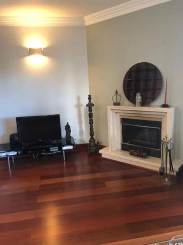 a living room with a fireplace and a flat screen tv at Villa Ávilla. Luxo e Charme. in Cascais
