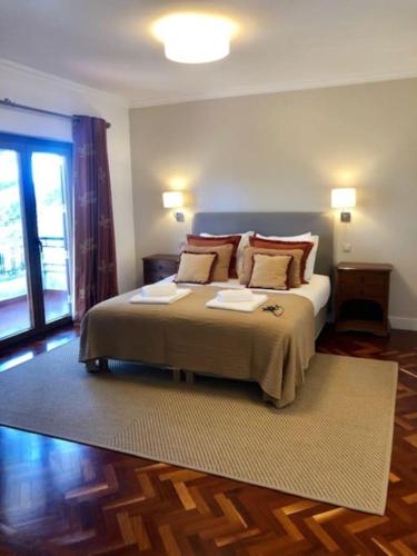 Un dormitorio con una cama con almohadas. en Villa Ávilla. Luxo e Charme., en Cascais