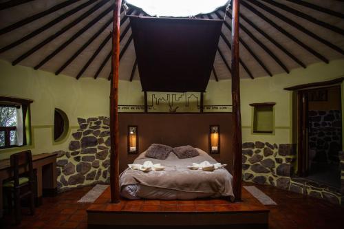 a bedroom with a canopy bed in a house at Ayni Wasi in Coporaque