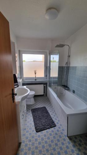 a bathroom with a tub and a toilet and a sink at Bocholt Apartment Ferienwohnung 3 in Bocholt