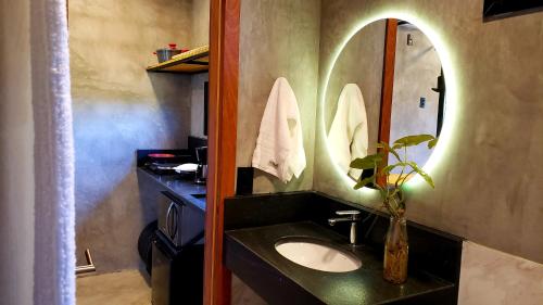 a bathroom with a sink and a mirror at Hospedagem Bangalô Patrimônio da Penha in Divino de São Lourenço