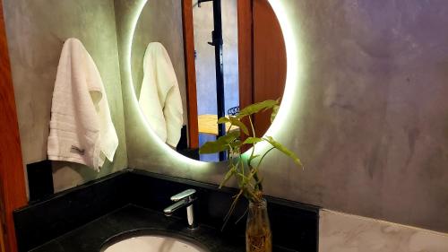 bagno con lavandino e specchio di Hospedagem Bangalô Patrimônio da Penha a Divino de São Lourenço