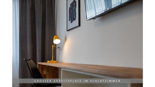 einen Schreibtisch mit einer Lampe und einem Stuhl in einem Zimmer in der Unterkunft Apartment Leinetal, mit Kamin, Seenähe, Harz Nähe in Northeim