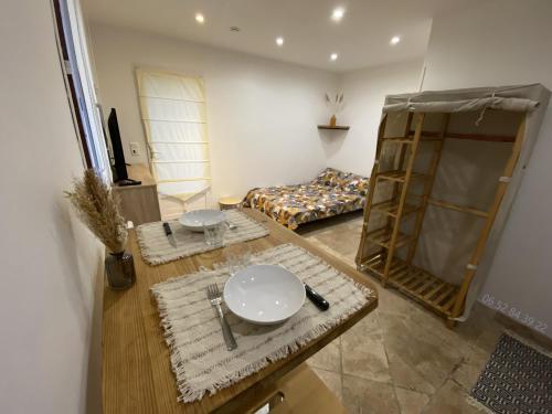 un salon avec une table et un lit dans l'établissement Studios villa coincoin, à La Garde