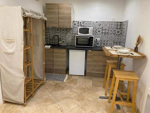 une petite cuisine avec un comptoir et un micro-ondes dans l'établissement Studios villa coincoin, à La Garde