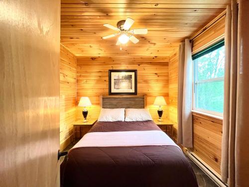 1 dormitorio con 1 cama y ventilador de techo en Stargazers Cove Cottages Otter, en Middleton