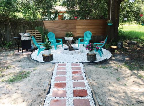 a patio with blue chairs and a table and a tree at Cozy 3BR Home near Weeki Wachee in Spring Hill