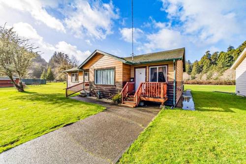 a log home with a porch and a lawn at Elk Meadow Cabins 9B Prairie Creek - Single Room in Orick