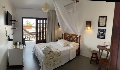um quarto com uma cama branca e uma varanda em Recanto Maria Flor em Flecheiras