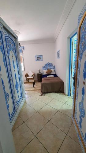 a bedroom with a bed and blue and white walls at Casa Familia in Chefchaouene