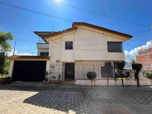 a white house with a gate in front of it at Casa Estrella Oaxaca in Oaxaca City
