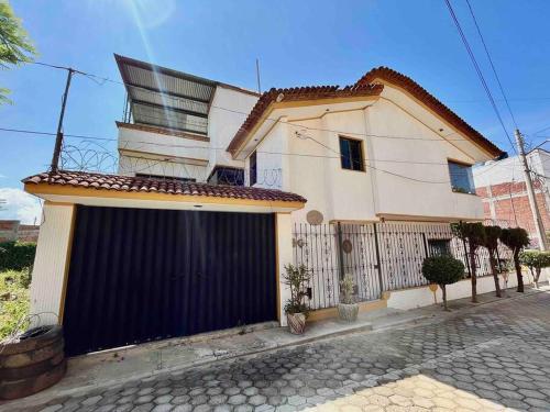 a white house with a black garage at Casa Estrella Oaxaca in Oaxaca City