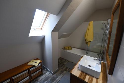 a bathroom with a sink and a bath tub at Auprès de mon arbre in Pontmain